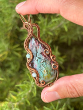 Load image into Gallery viewer, Artisan cab (positive rocks) rainbow fossilized palm root with garnet + amazonite gem accents wire wrapped pendant necklace
