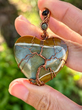 Load image into Gallery viewer, Artisan cab (positive rock) polychrome desert jasper with green tourmaline + blue tiger eye gem accents tree of life wrap wire wrapped pendant necklace
