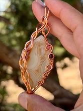 Load image into Gallery viewer, Artisan cab (positive rocks) orange botswana agate with sunstone + garnet gem accent wire wrapped pendant necklace
